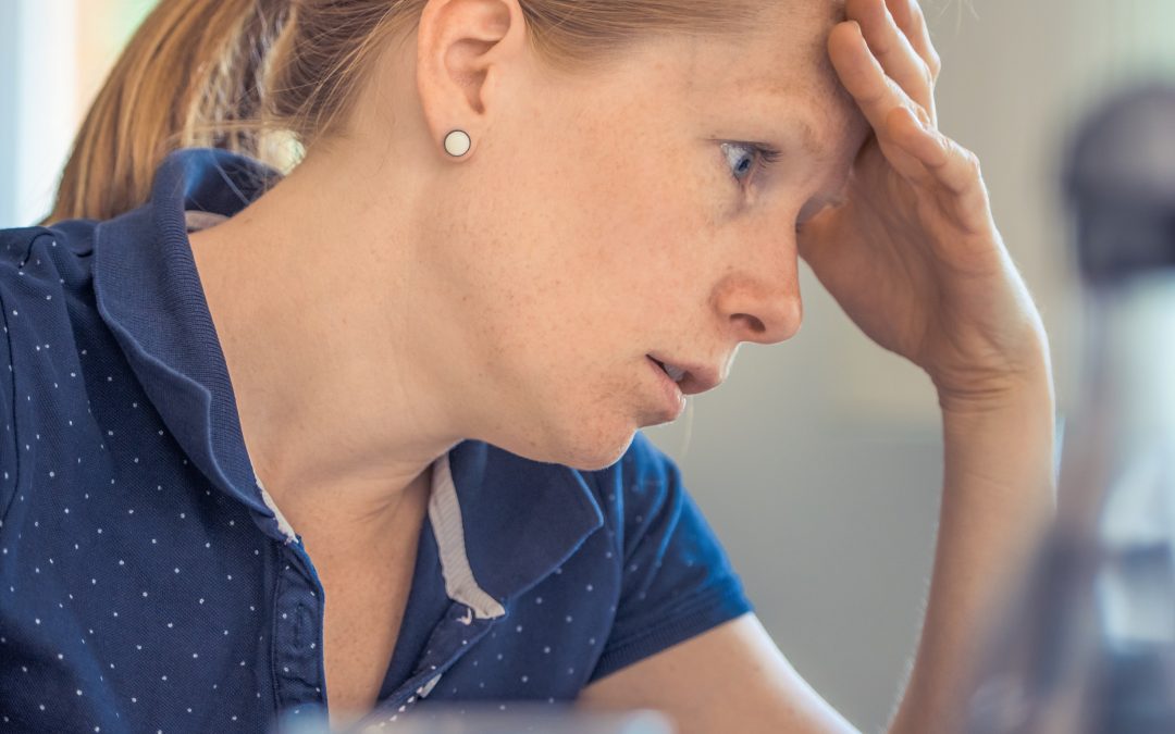 woman holding head in hands looking tired and exasperated, image used for lisa laporte blog on how to avoid burnout